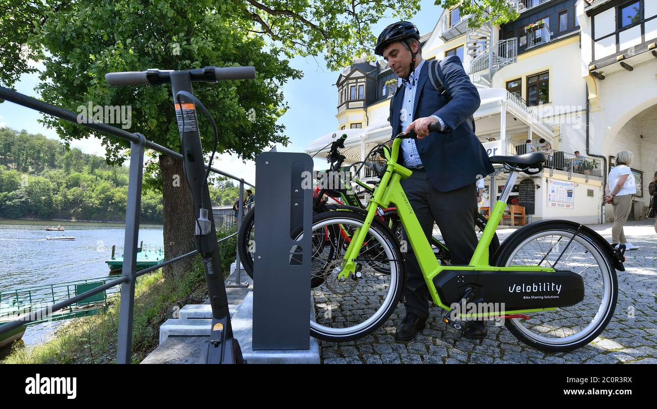 12 June 2020, Thuringia, Saalburg-Ebersdorf: Hannes Neupert from EnergyBus GmbH places an e-bike at the new e-bike charging station, which was put into operation the same day at the Fahrgastschifffahrt Saalburg. Further stations are to follow in order to boost cycle tourism in the reservoir region known as the 'Thuringian Sea' at the Bleiloch Dam and the Hohenwarte Reservoir. Photo: Martin Schutt/dpa-Zentralbild/dpa Stock Photo