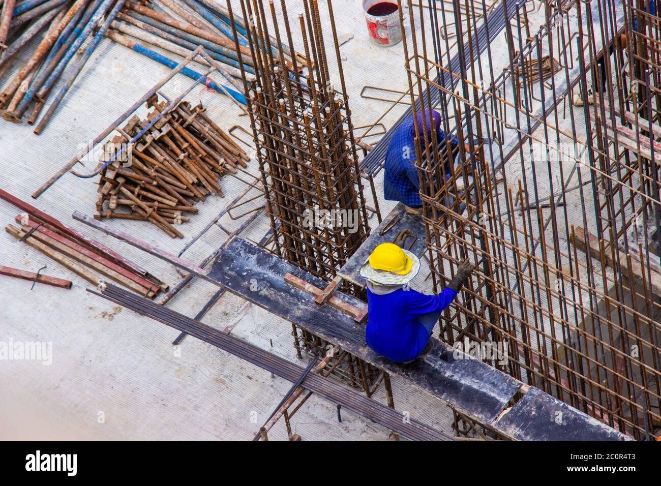 Construction workers fabricating large steel bar reinforcement bar at