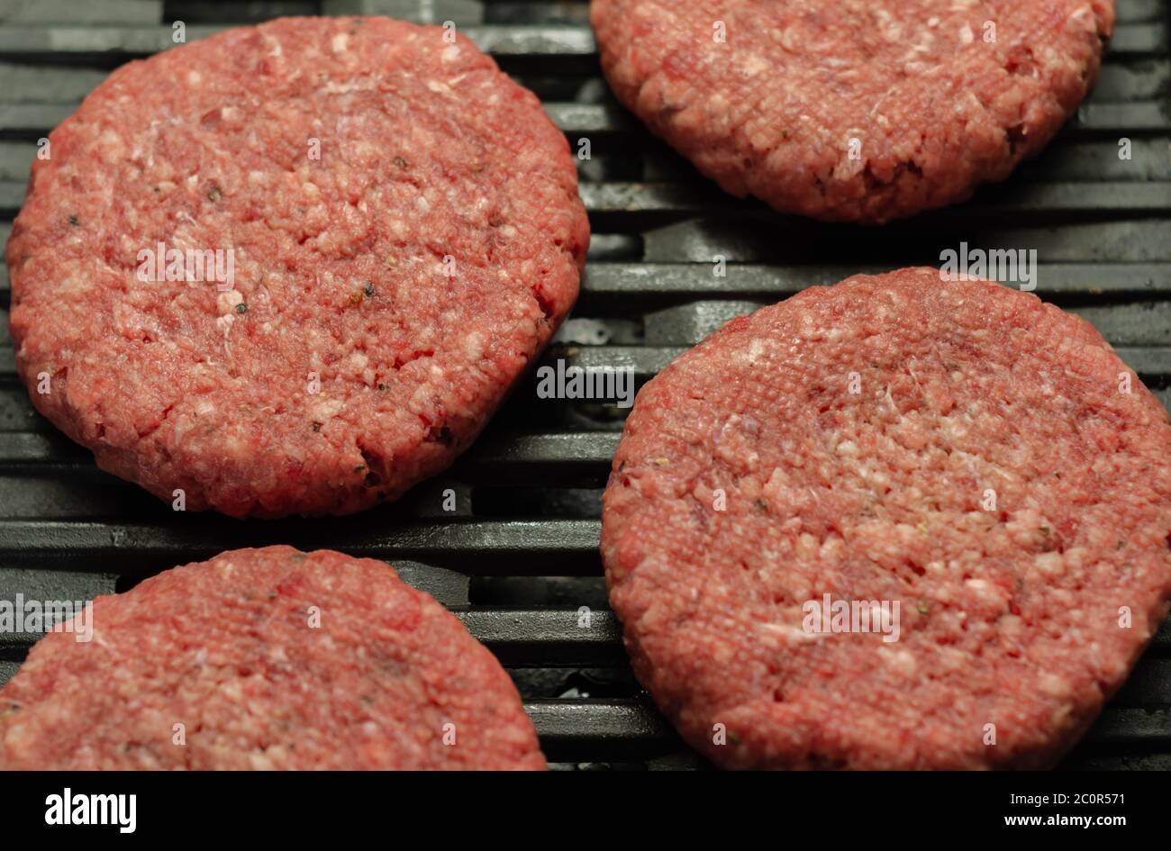 Seasoned beef burgers with a pinch of salt and black pepper on the