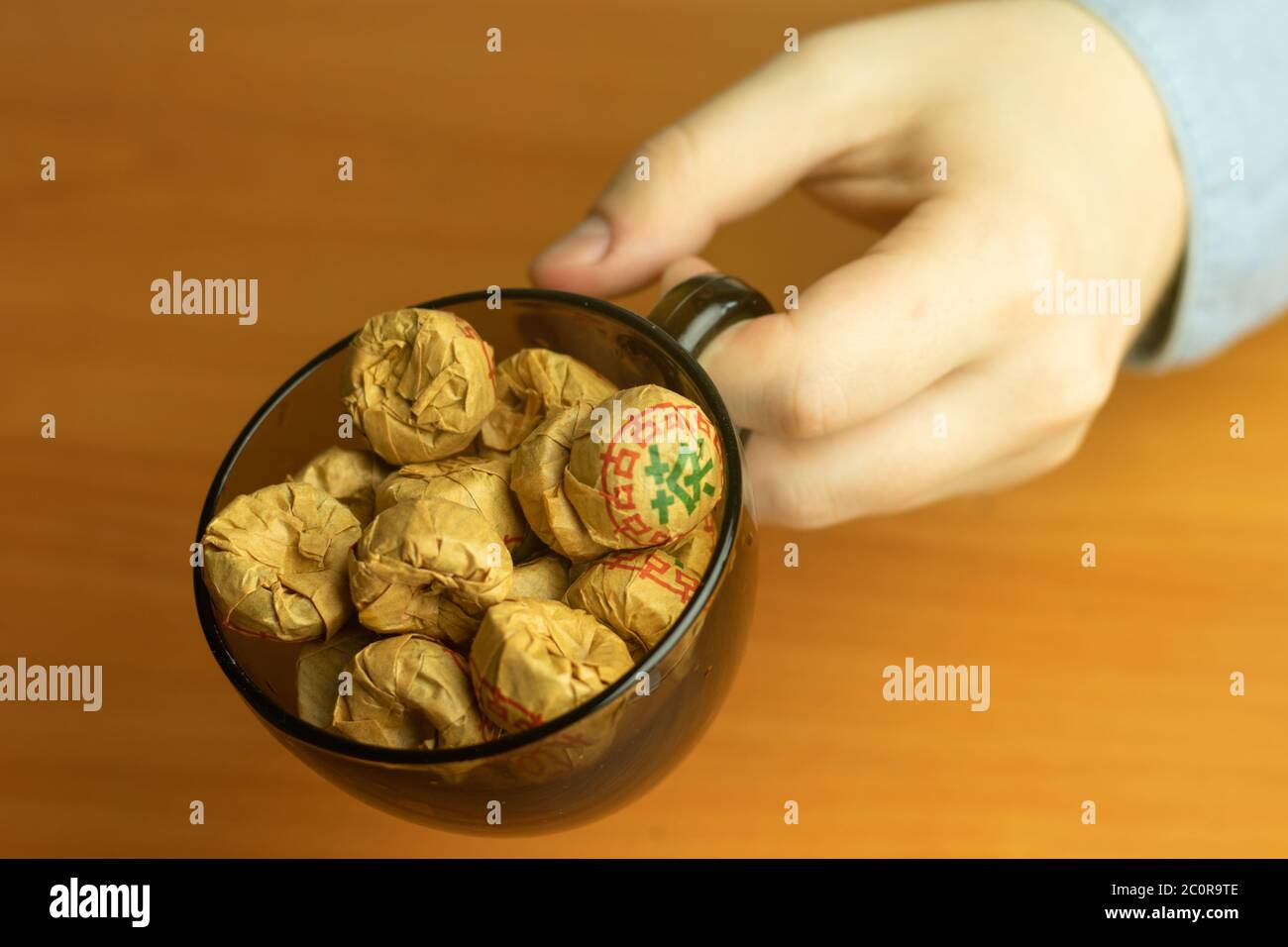 Chinese Puer herbal tea in a package in a cup in hand close-up. Stock Photo