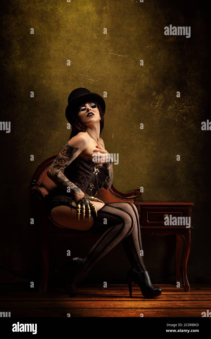 Portrait of a young sexy woman in Victorian lingerie, wearing a top hat and  a pair of glasses Stock Photo - Alamy