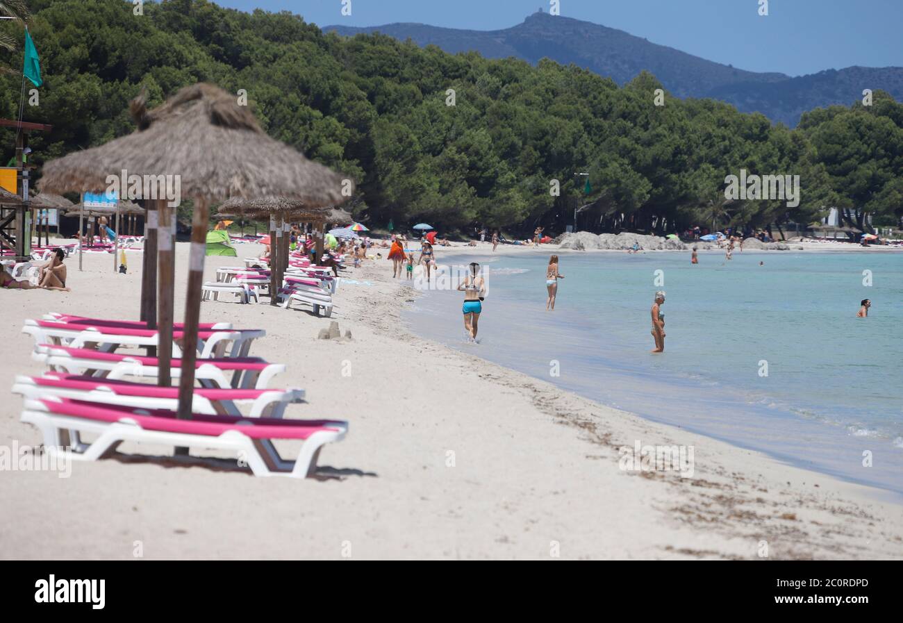 12 June 2020, Spain, Alcudia: People bathe in the sea at the beach de Muro in the north of Mallorca. With up to 10 900 holidaymakers from Germany, the Balearic Islands are gradually being visited from 15 June onwards. Photo: Clara Margais/dpa Stock Photo