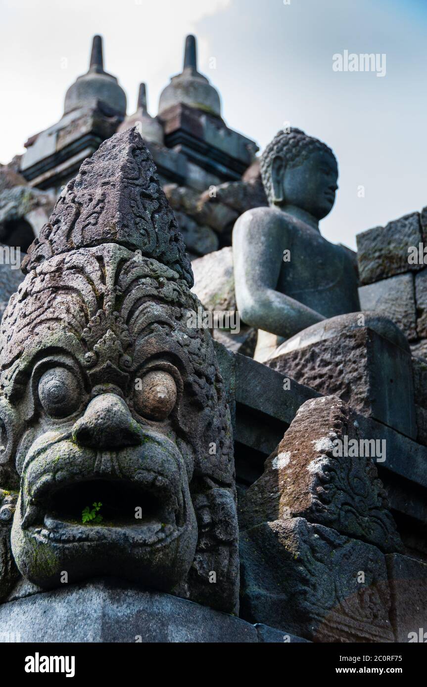 Big Eyed Sculpture and sitting stone Buddha at Borobudur temple Stock Photo