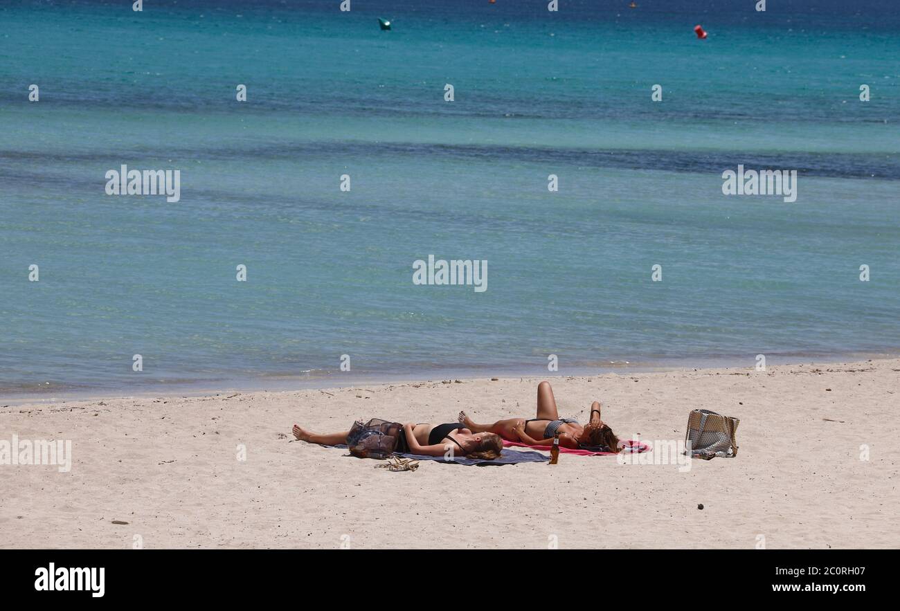 Mallorca, Spain. 12th June, 2020. Women sunbathe on the beach de Muro. Mallorca is getting ready for the new season. With up to 10,900 holidaymakers from Germany, the Balearic Islands will gradually be allowed to welcome up to 10,900 tourists from 15 June. Credit: Clara Margais/dpa/Alamy Live News Stock Photo