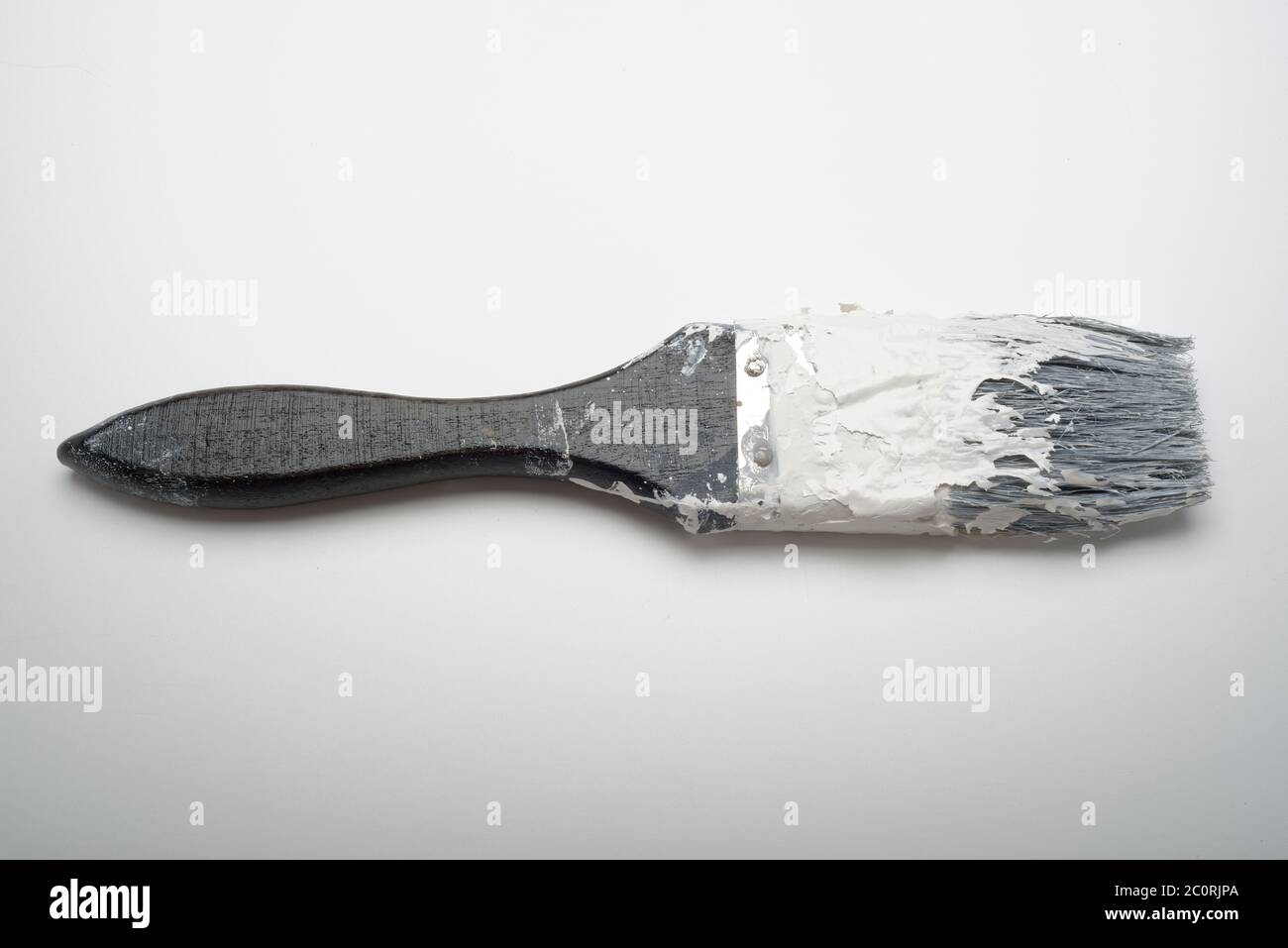 An old paint hardened paintbrush. A brush that has been left uncleaned