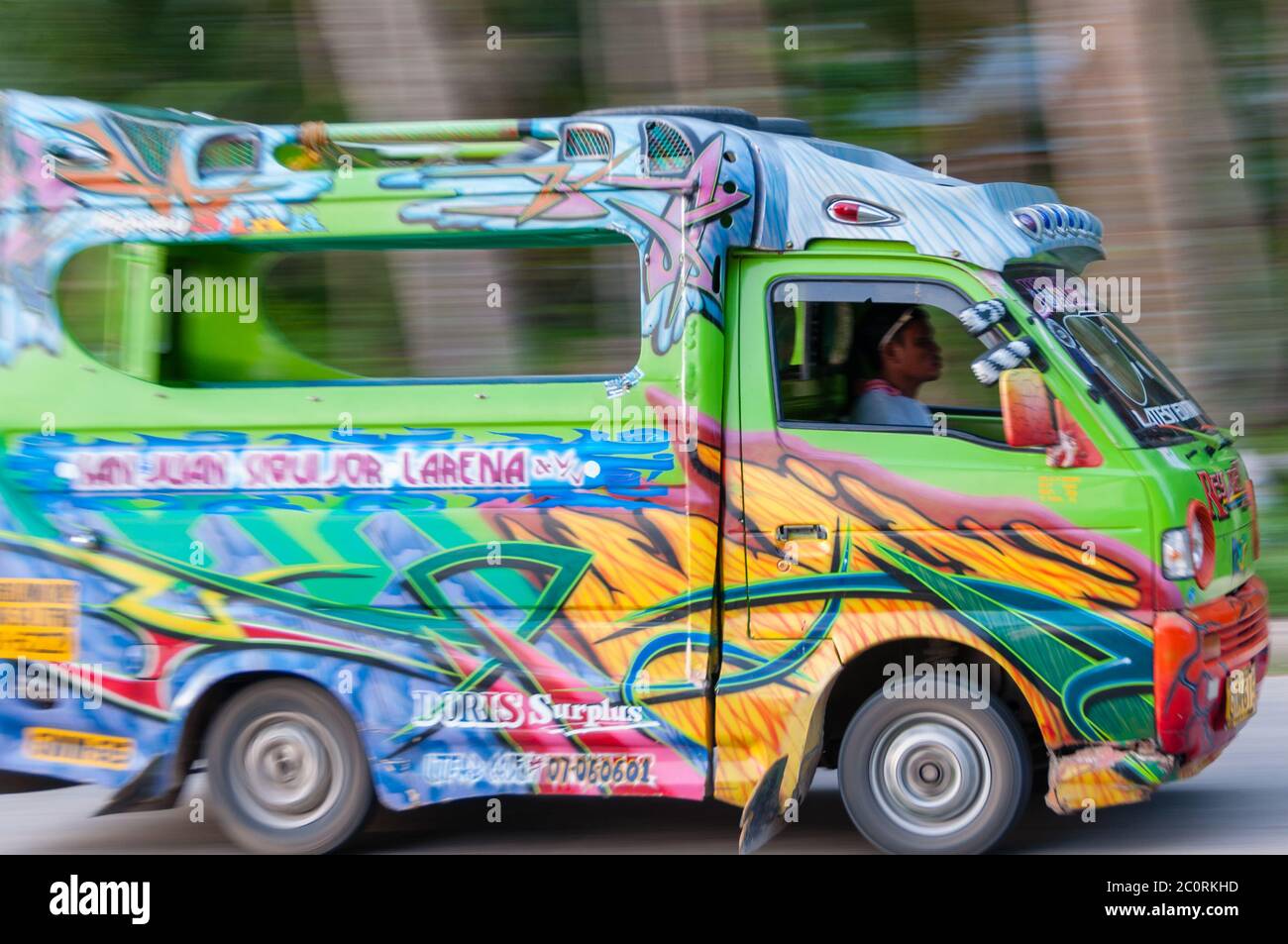 FIlipino Man Driving a Very Colorful Jeepney mini van Stock Photo