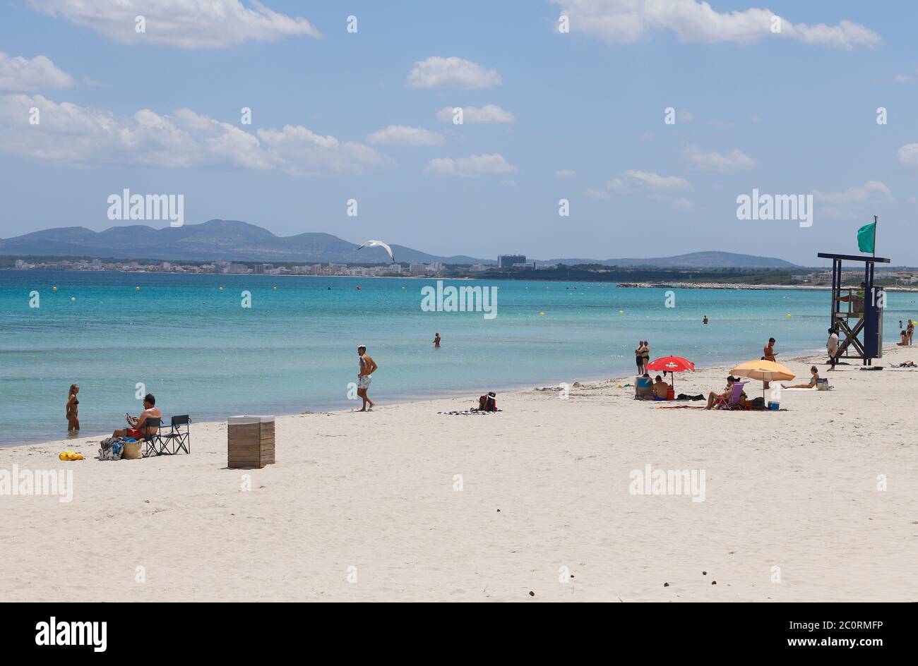 Mallorca, Spain. 12th June, 2020. People enjoy the beach de Muro. Mallorca is preparing for the new summer season. With up to 10,900 holidaymakers from Germany, the Balearic Islands will gradually be opened to the public from 15 June. Credit: Clara Margais/dpa/Alamy Live News Stock Photo