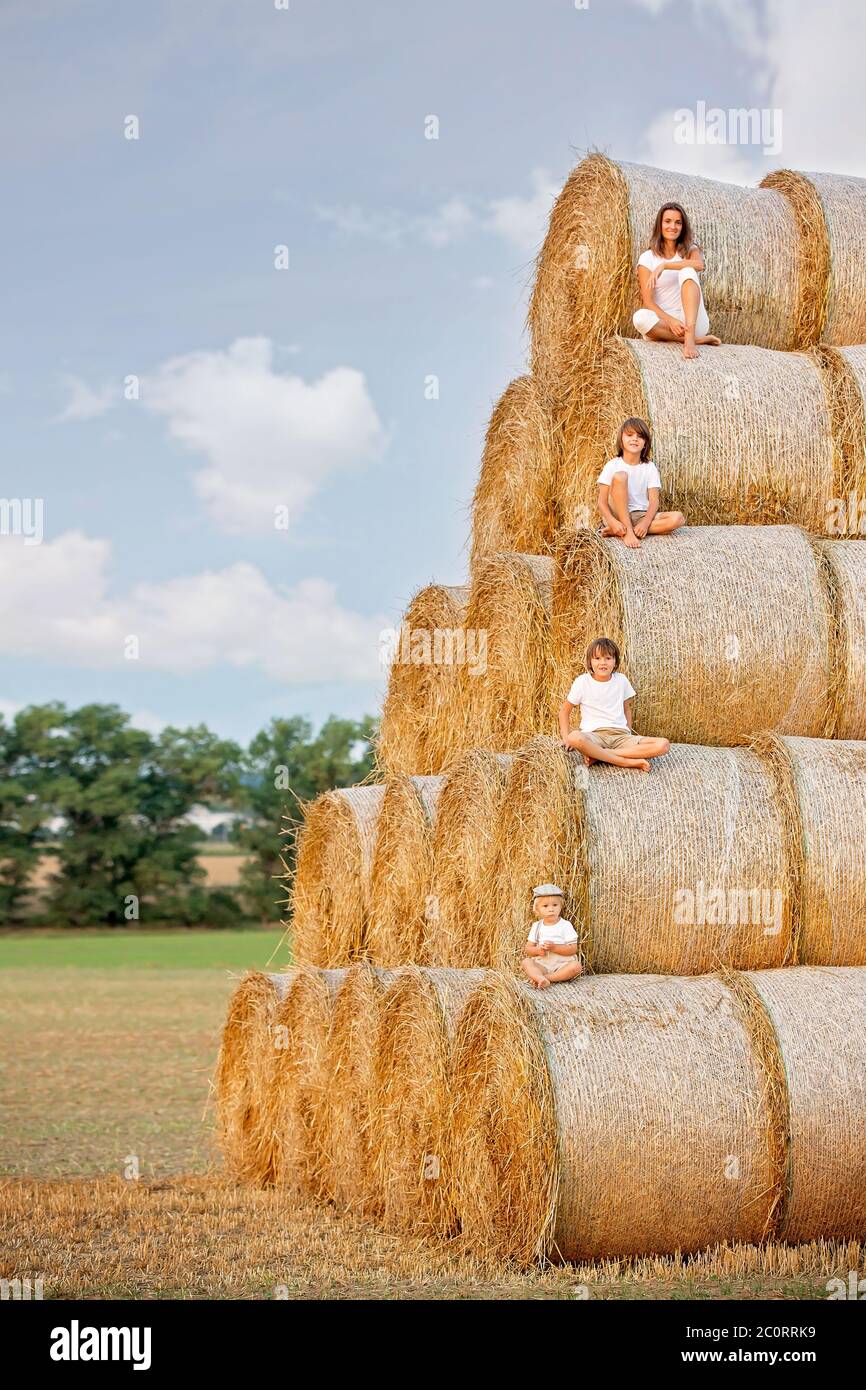 Happy family, sitting on a haystack, every member of the family sitting ...