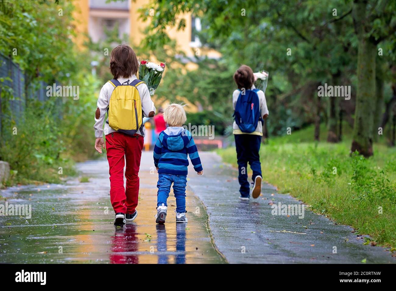 happy-school-children-holding-bouquet-of-flowers-going-to-school