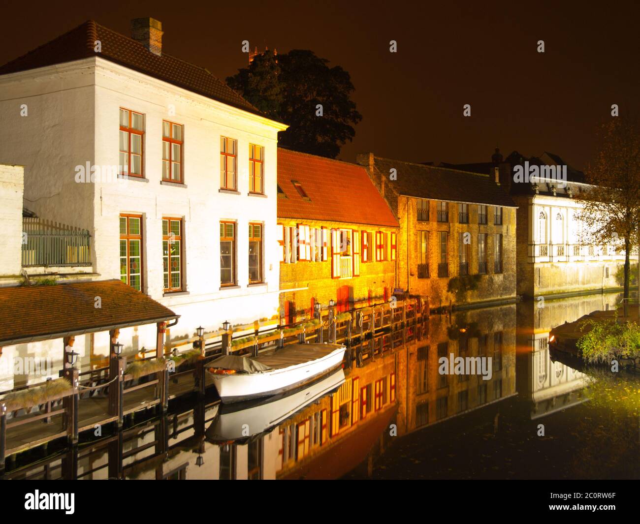 Bruges by night. Calm Dijver canal with boat in the dock. Belgium. Stock Photo
