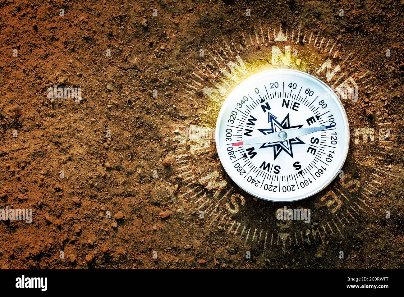 White compass on brown earth background, flat top view, find the way and travel concept Stock Photo