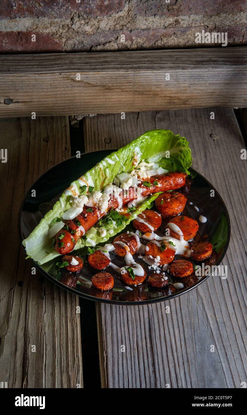 Fancy gourmet glutenfree lettuce wrap hot dog with sliced carrots