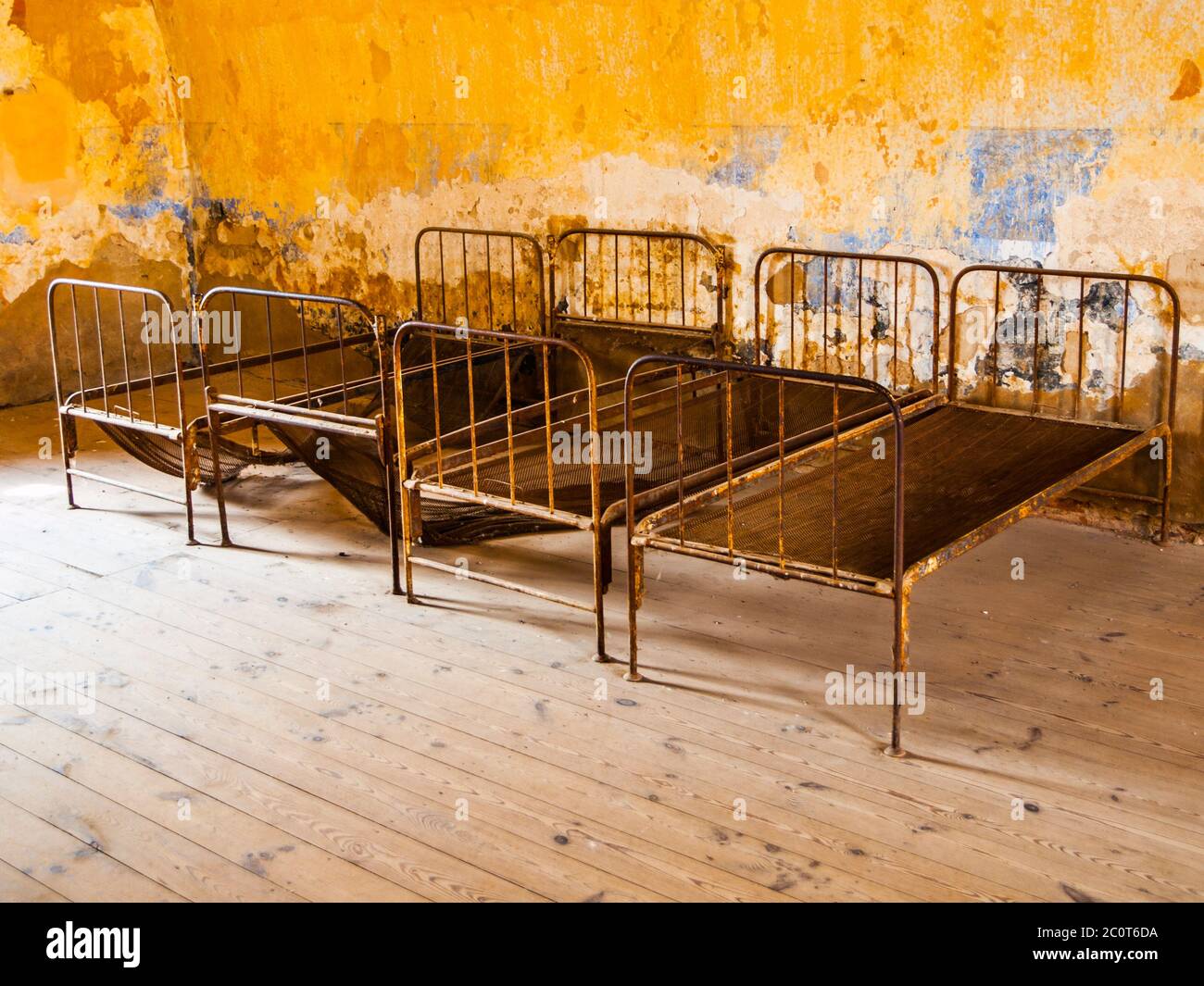 Four old rusty beds in abandoned room Stock Photo