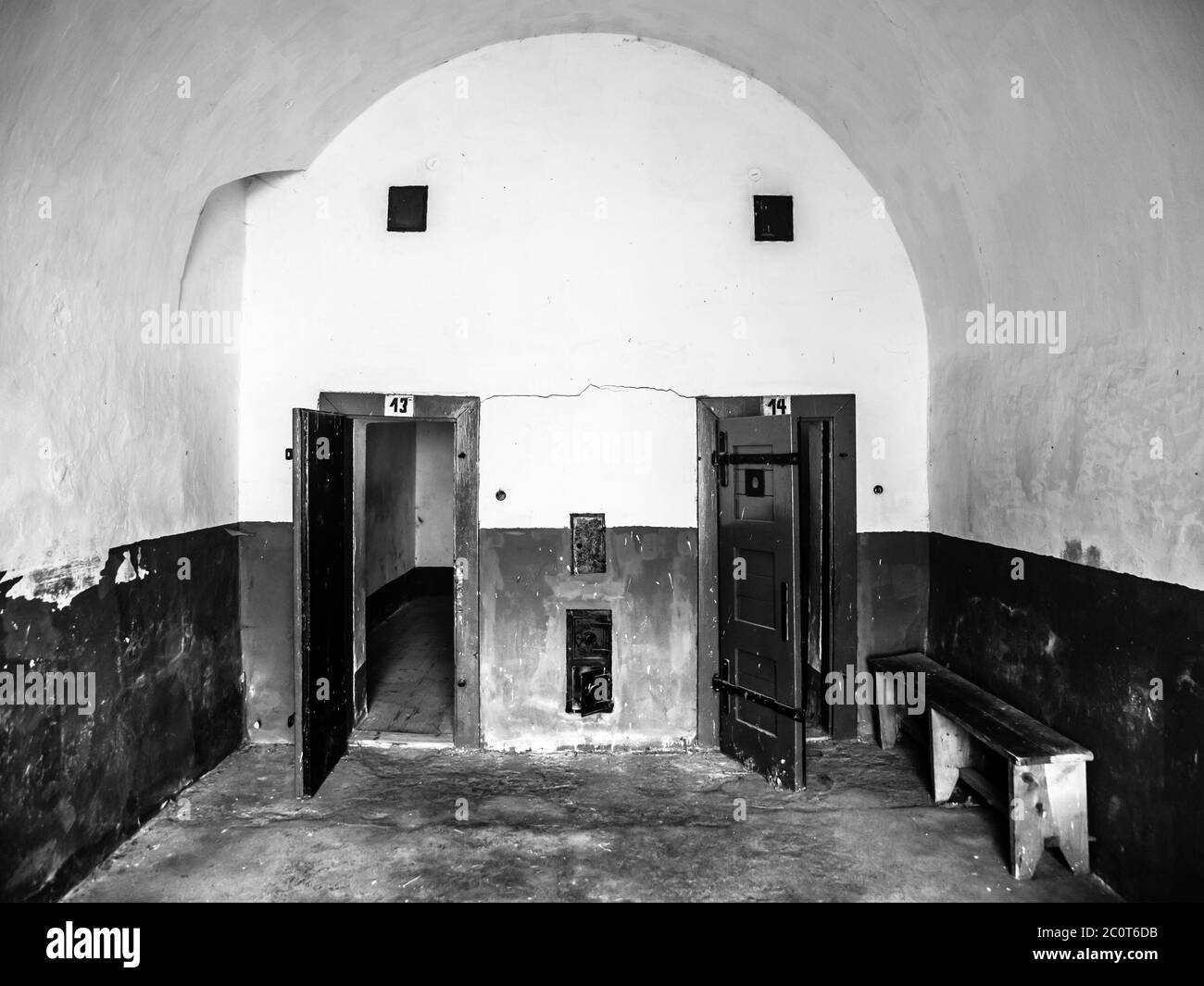 Two old prison cells with wooden door. View from corridor. Black and white image. Stock Photo