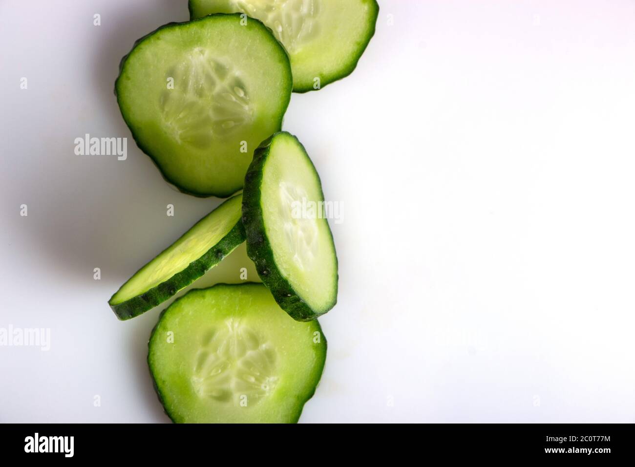 fresh green cucumber, cut with rings on a white background Stock Photo ...