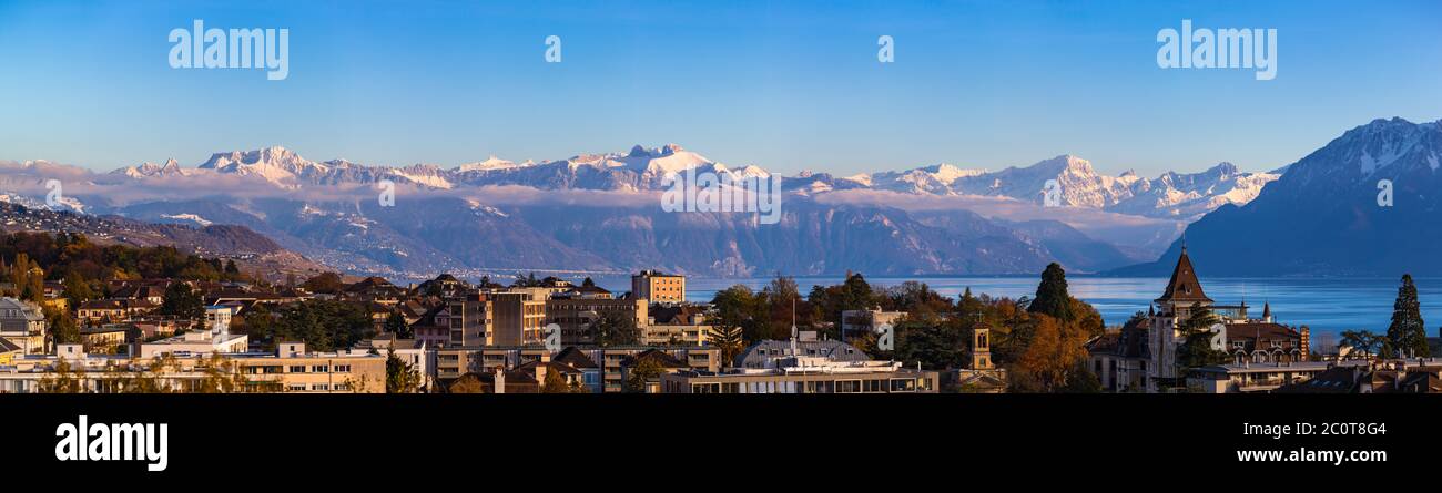 Stunning aerial panorama view of Lausanne cityscape with Lake Geneva (Lake Leman) and snow convered French Alps in background on a sunny autumn day wi Stock Photo