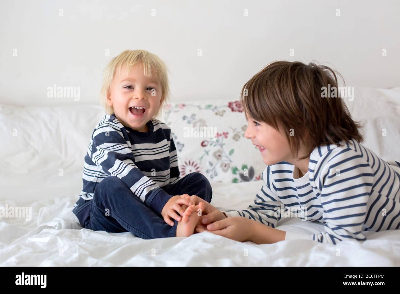 Children, brothers, playing at home, tickling feet laughing and smiling
