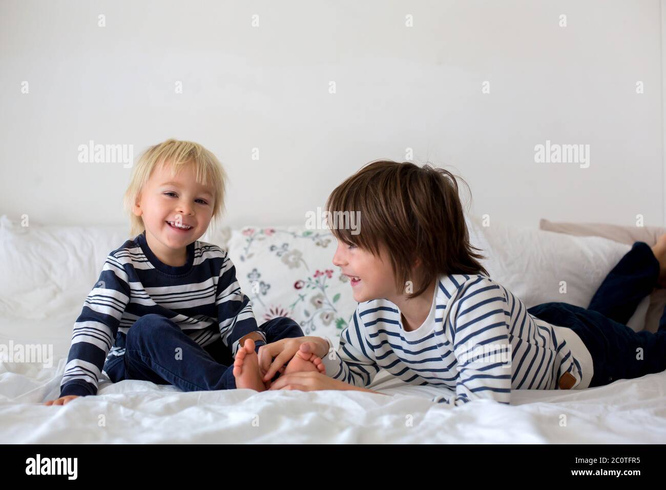 Children, brothers, playing at home, tickling feet laughing and smiling Stock Photo