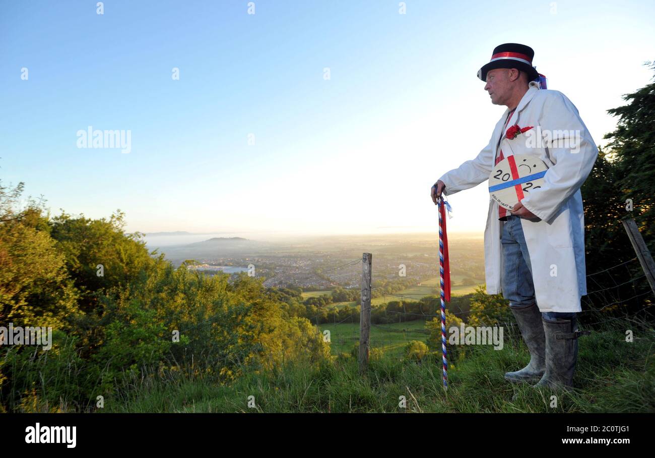 The Cheese Rolling Master of Ceremonies Jem Wakeman rolls the ceremonial cheese down Cooper's Hill, Gloucestershire just before 5.30am Stock Photo