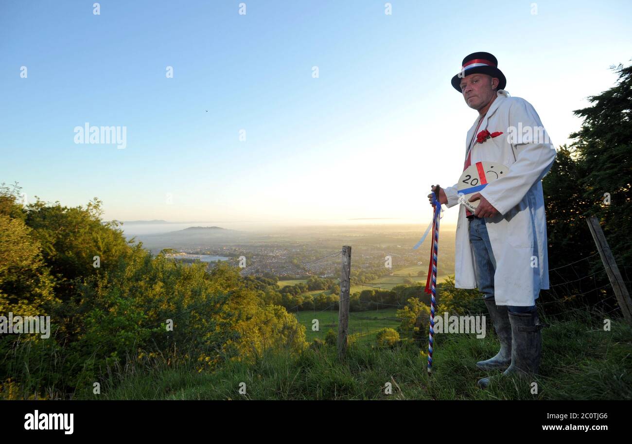 The Cheese Rolling Master of Ceremonies Jem Wakeman rolls the ceremonial cheese down Cooper's Hill, Gloucestershire just before 5.30am Stock Photo