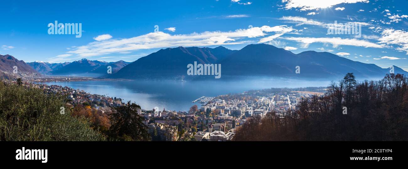 Stunning aerial panorama view of  Locarno cityscape and Lake Maggiore from Madonna del Sasso church, snow covered Swiss Alps mountain and blue sky clo Stock Photo