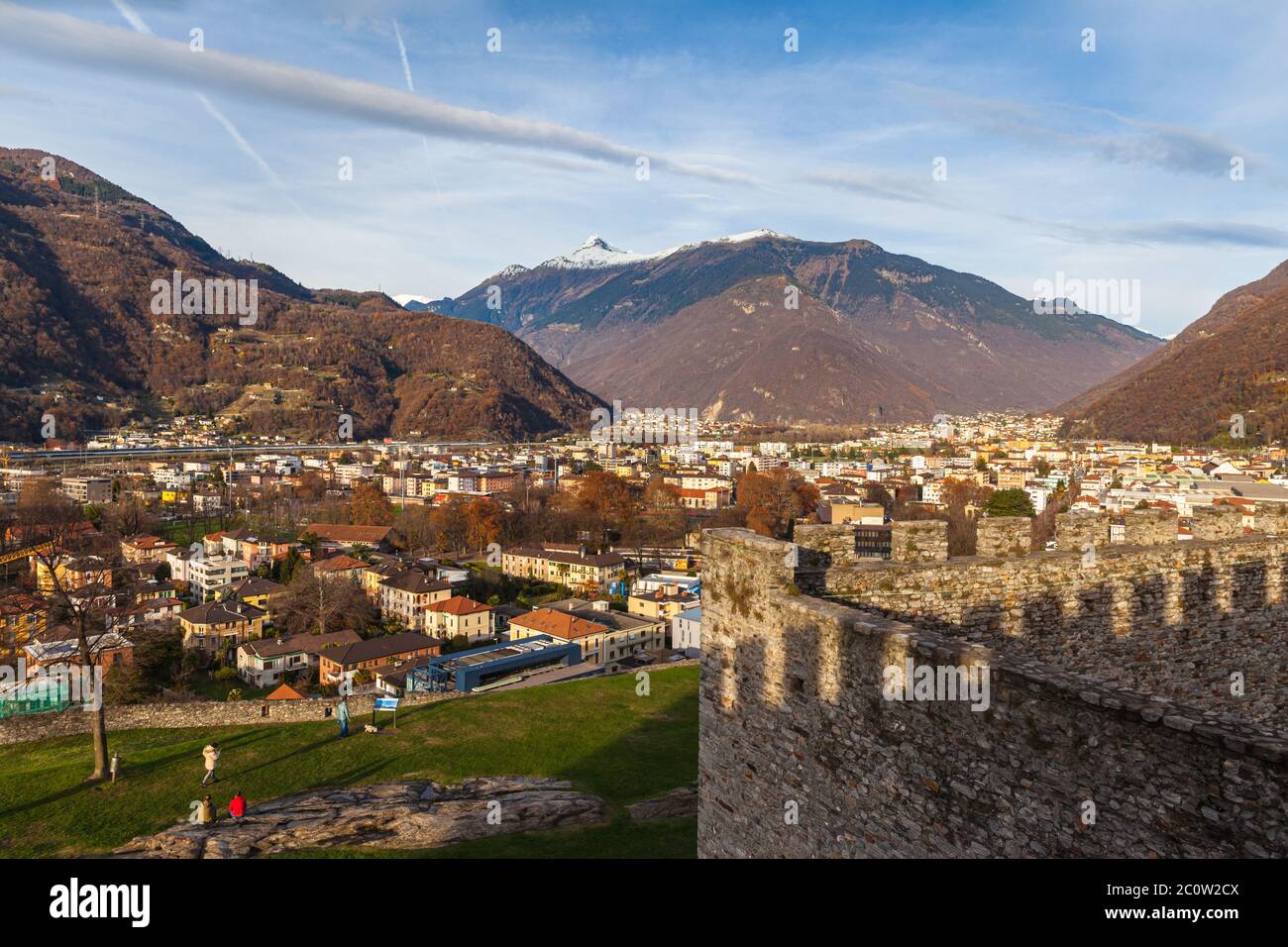 Stunning aerial panorama view of Bellinzona cityscape in beautiful sunlight from Castelgrande Castle with Swiss Alps and blue sky cloud in background, Stock Photo