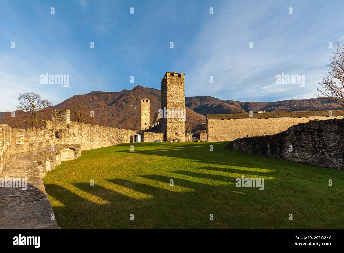 Beautiful of Castelgrande Castle ruin and in sunshine in autumn with colourful tree and green grass and Swiss Alps mountain, Bellinzona, Ticino, Switz Stock Photo