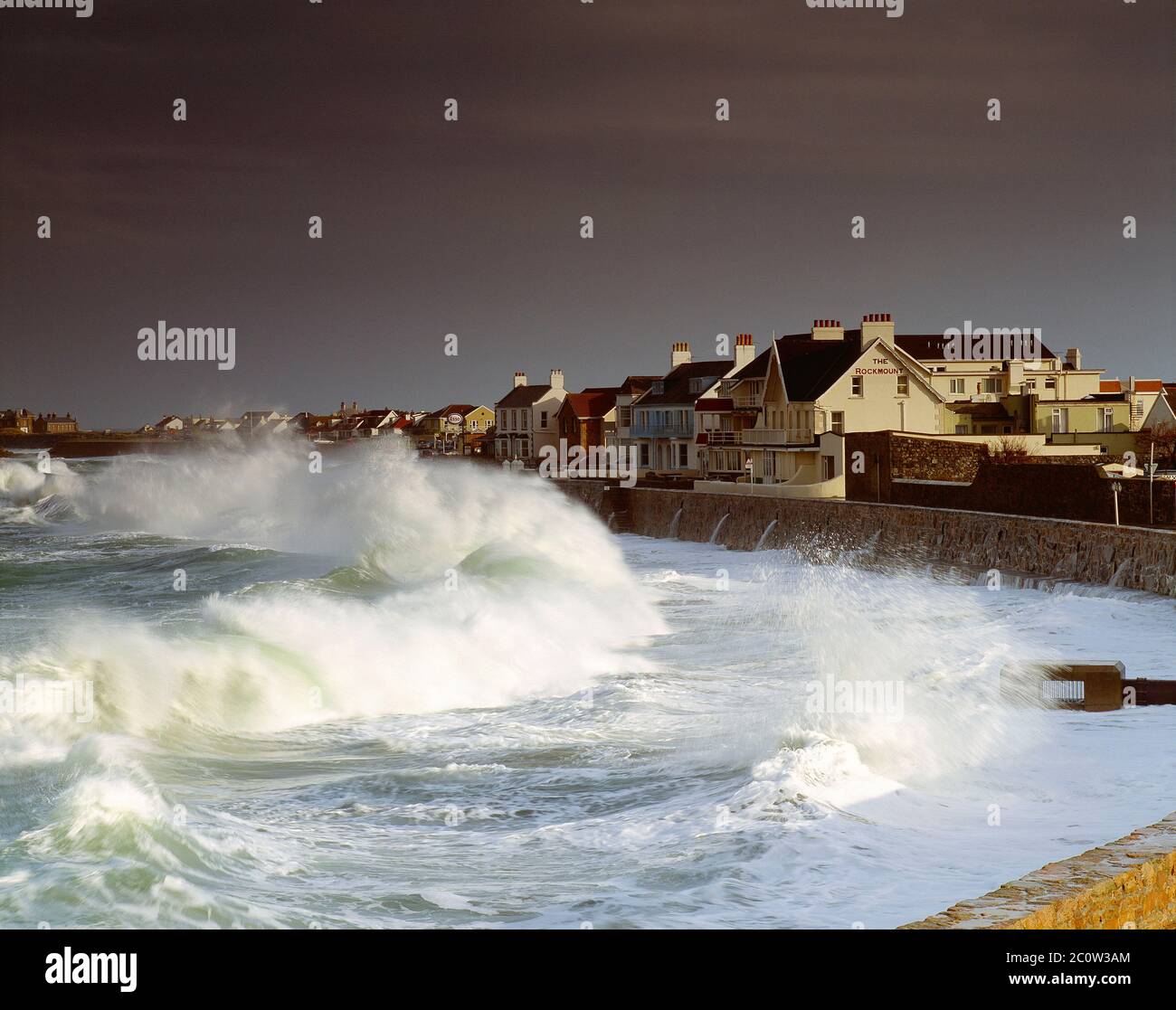 Channel Islands. Guernsey. Cobo Bay seafront houses with surf Stock