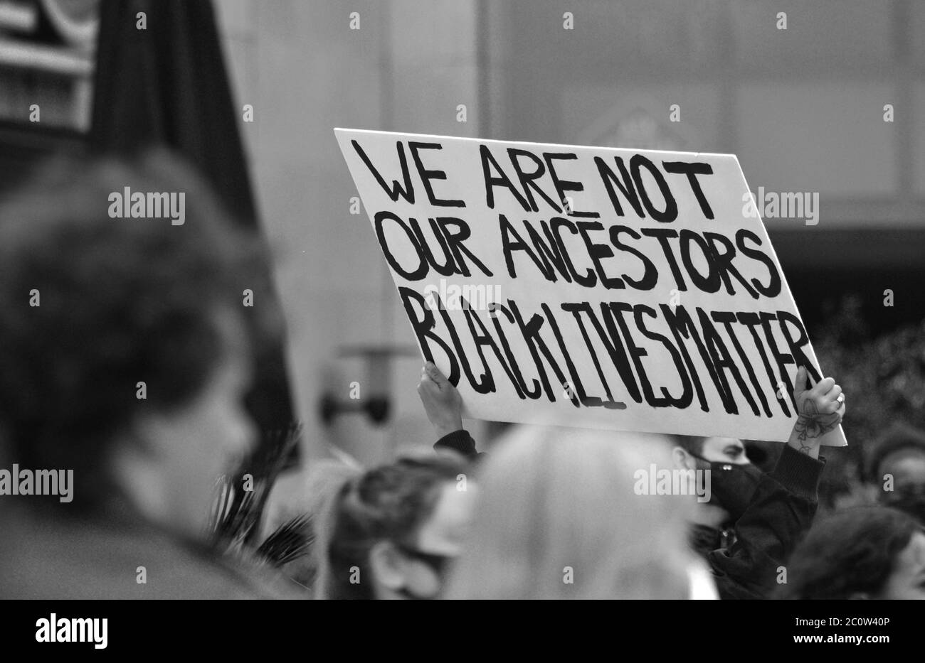 A banner being held up at a British Black Lives Matter protest in 2020 that reads 'We Are Not Our Ancestors Black Lives Matter' Stock Photo