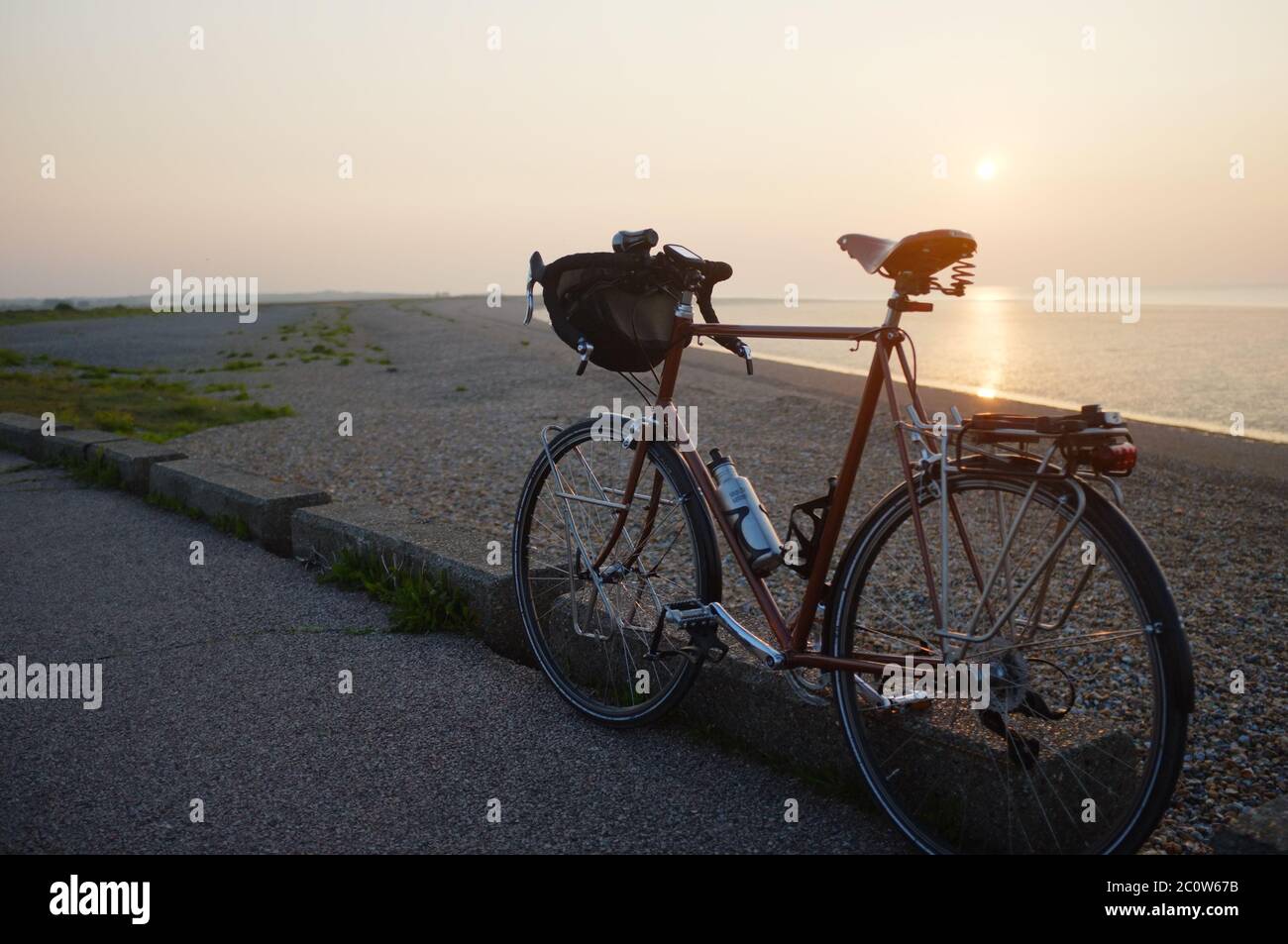 Riding at sunset on a classic racing bicycle. Stock Photo