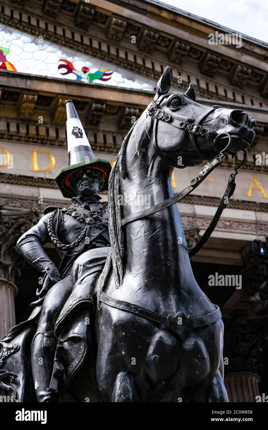 Glasgow, Scotland, UK. 12 June 2020. Famous statue of Duke of Wellington with traffic cone on his head . This time the traffic cone is replaced with a black one representing Black Lives Matter protest movement. Iain Masterton/Alamy Live News Stock Photo