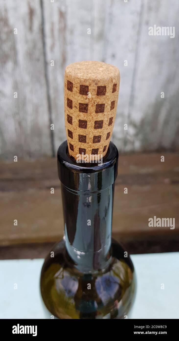 Square dots on wine cork of green glass bottle with red wine. Classic