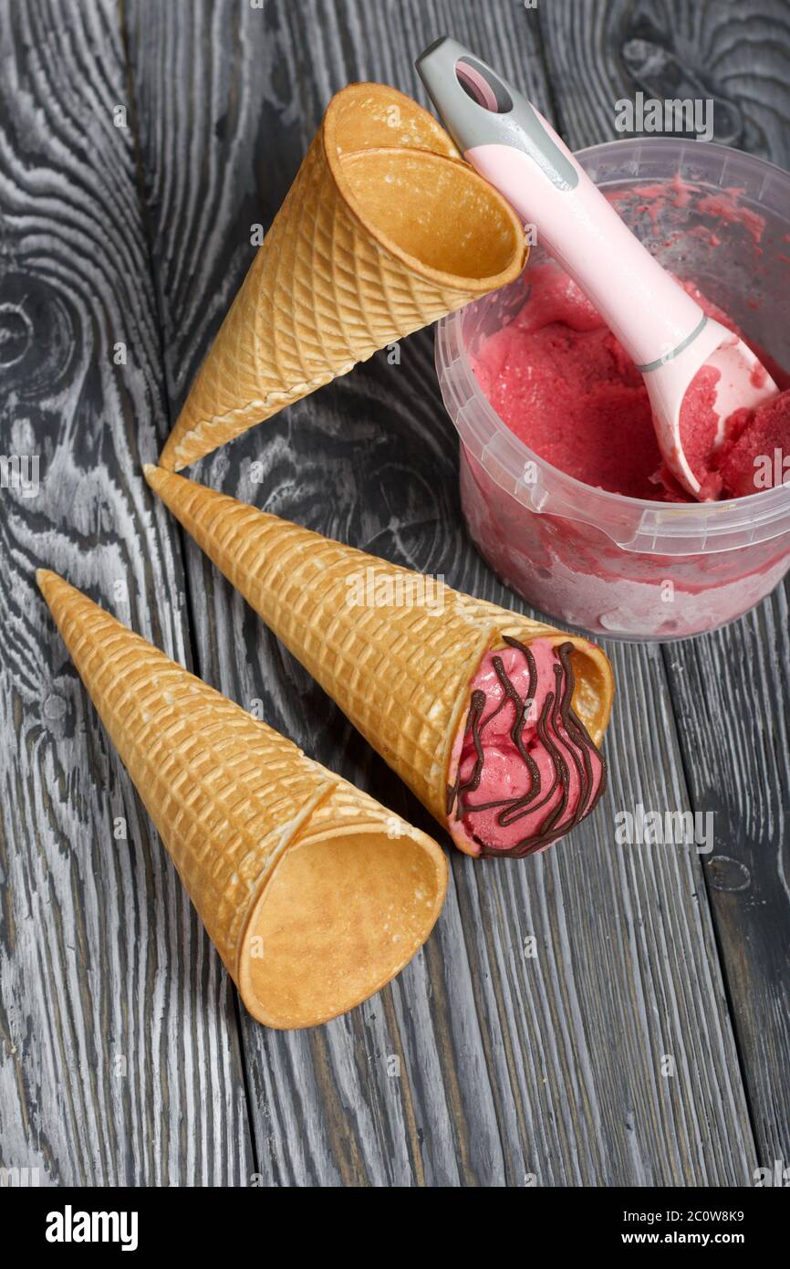 Strawberry ice cream in a waffle cone. Garnished with Chocolate. Nearby