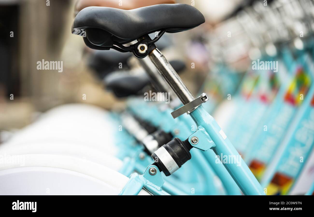 (Selective focus) Bicycle sharing system with some blurred bikes parked in George Town, Penang, Malaysia. Stock Photo
