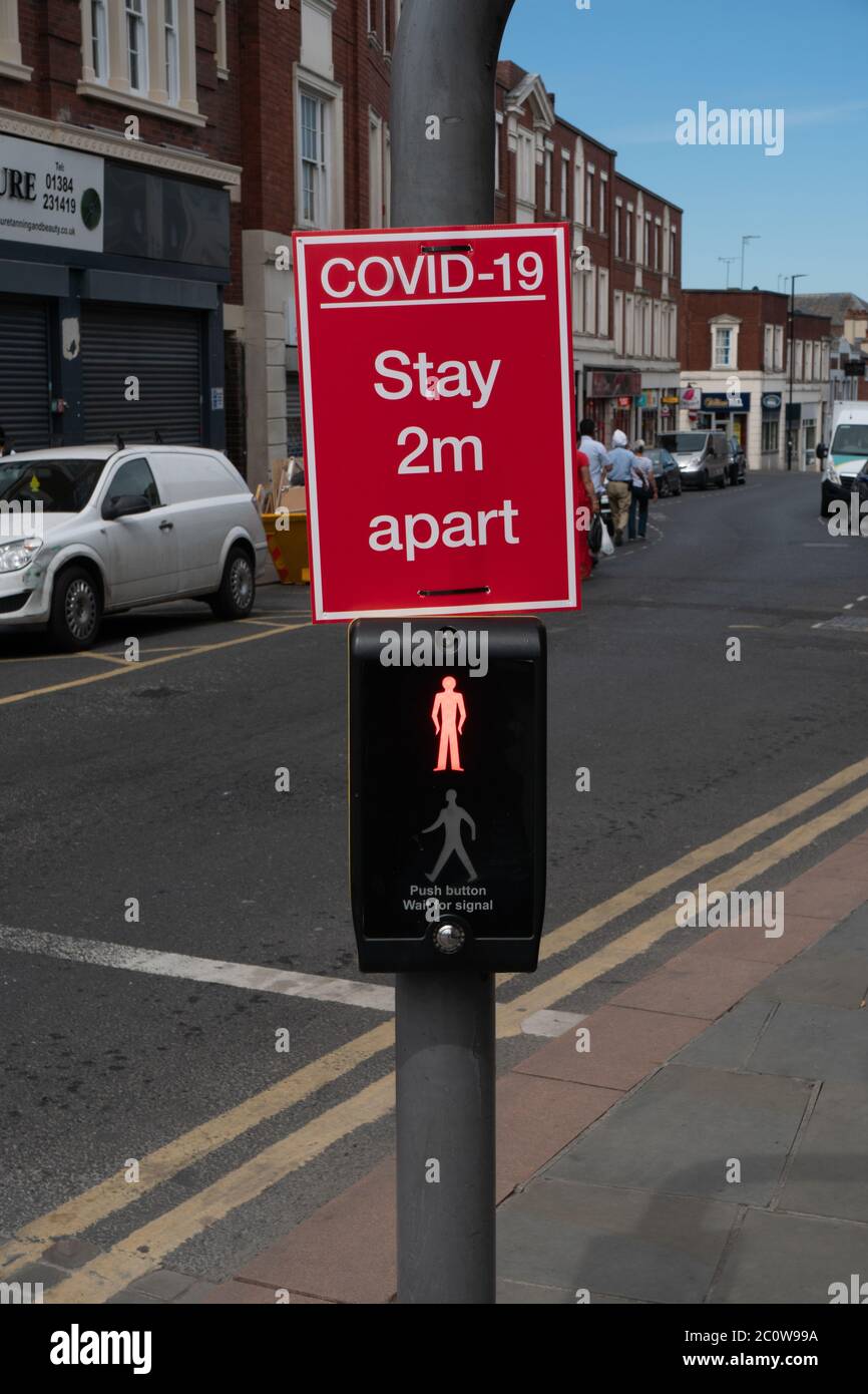 Social distancing sign on pedestrian light. Dudley, West Midlands. UK Stock Photo