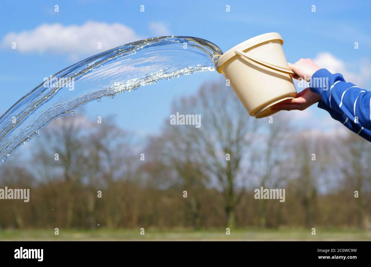 water is poured from a bucket Stock Photo