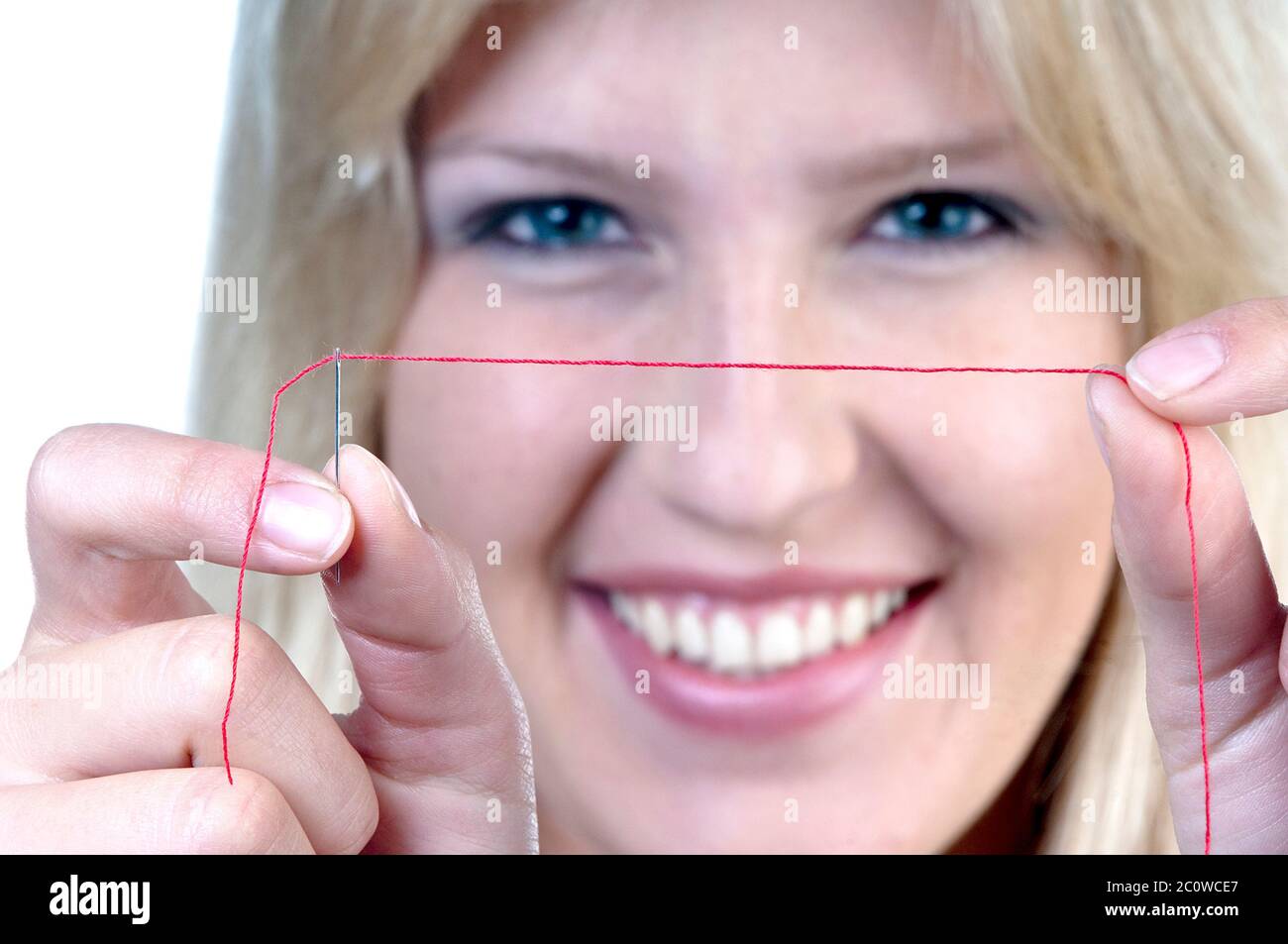 woman female face blonde sew sewing kit to approach woman laugh laughs laughing Stock Photo
