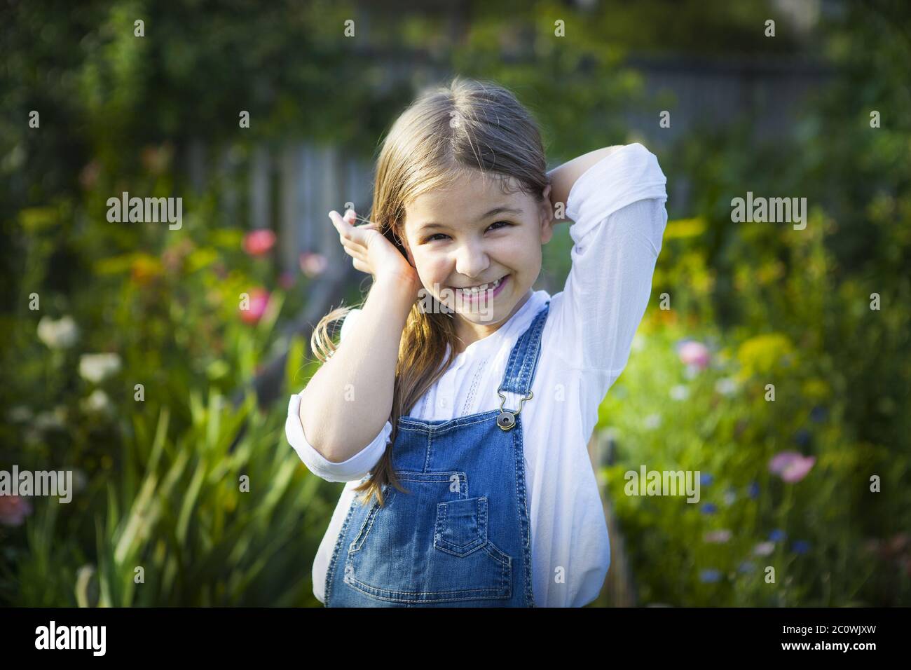 Portrait of happy smiling little girl in sunny garden Stock Photo - Alamy