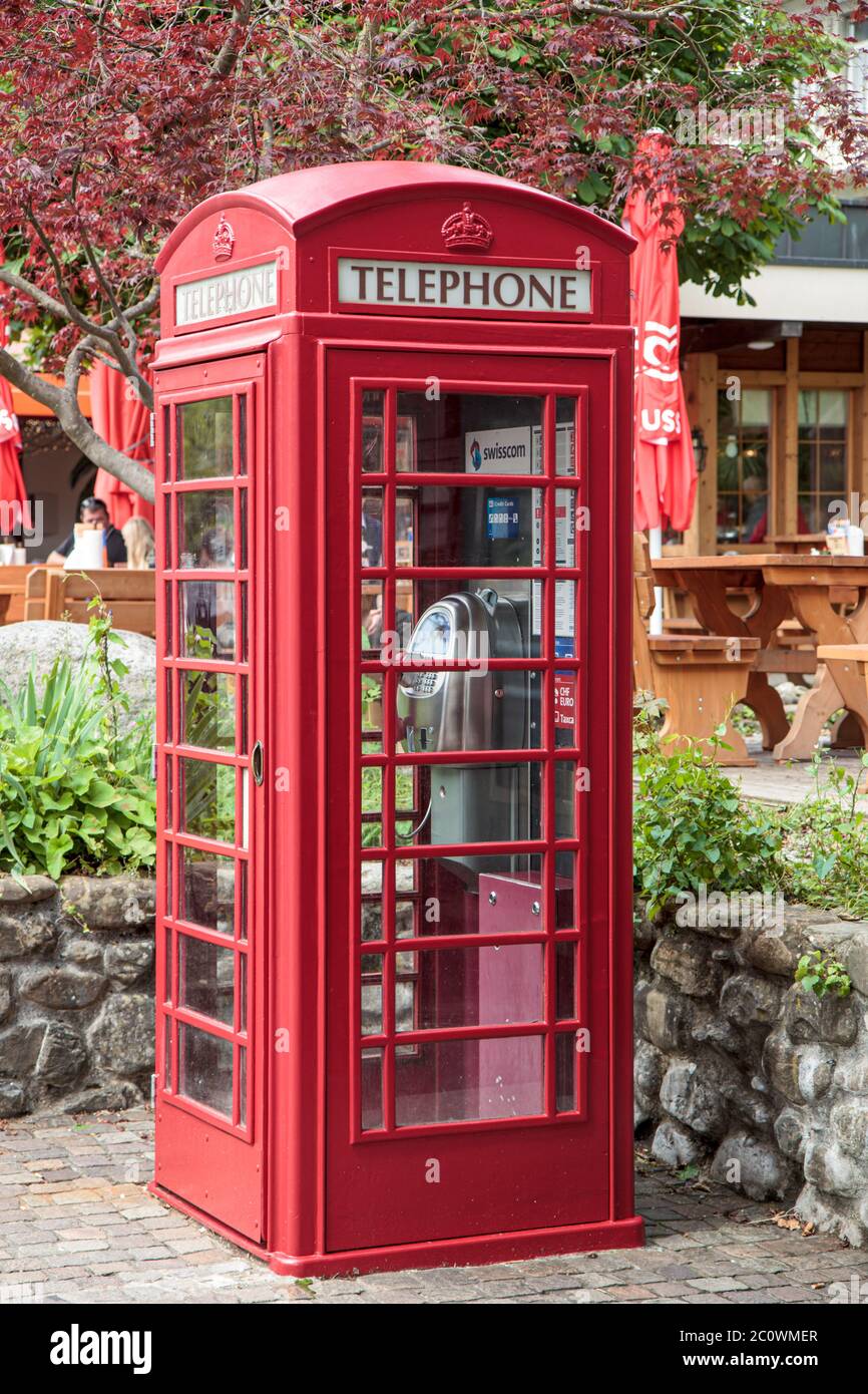 Swisscom public phone in classic red telephone booth Stock Photo