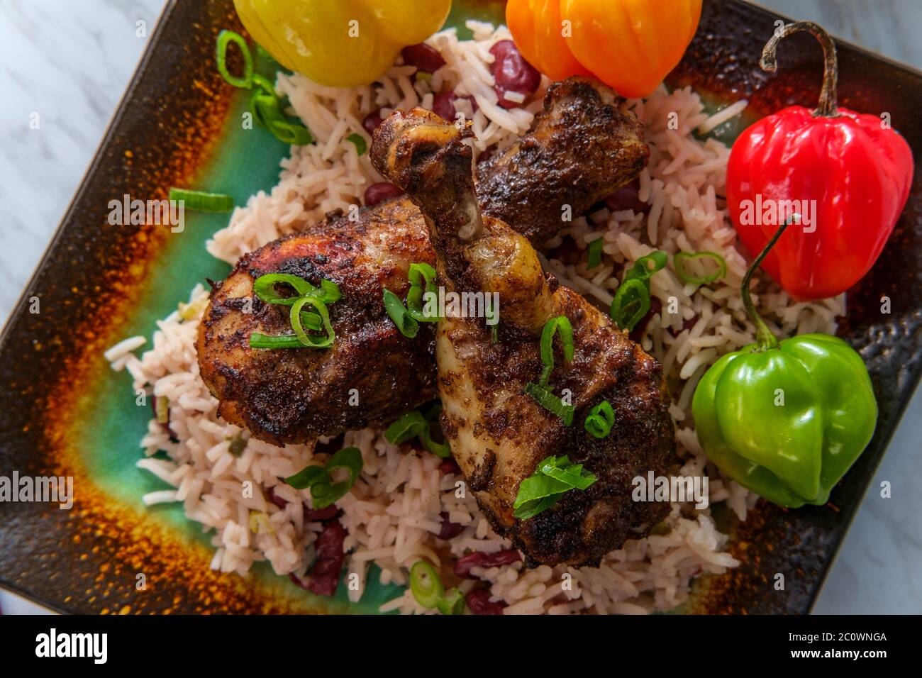 Authentic spicy Jamaican jerk chicken legs with scotch chili peppers served with coconut