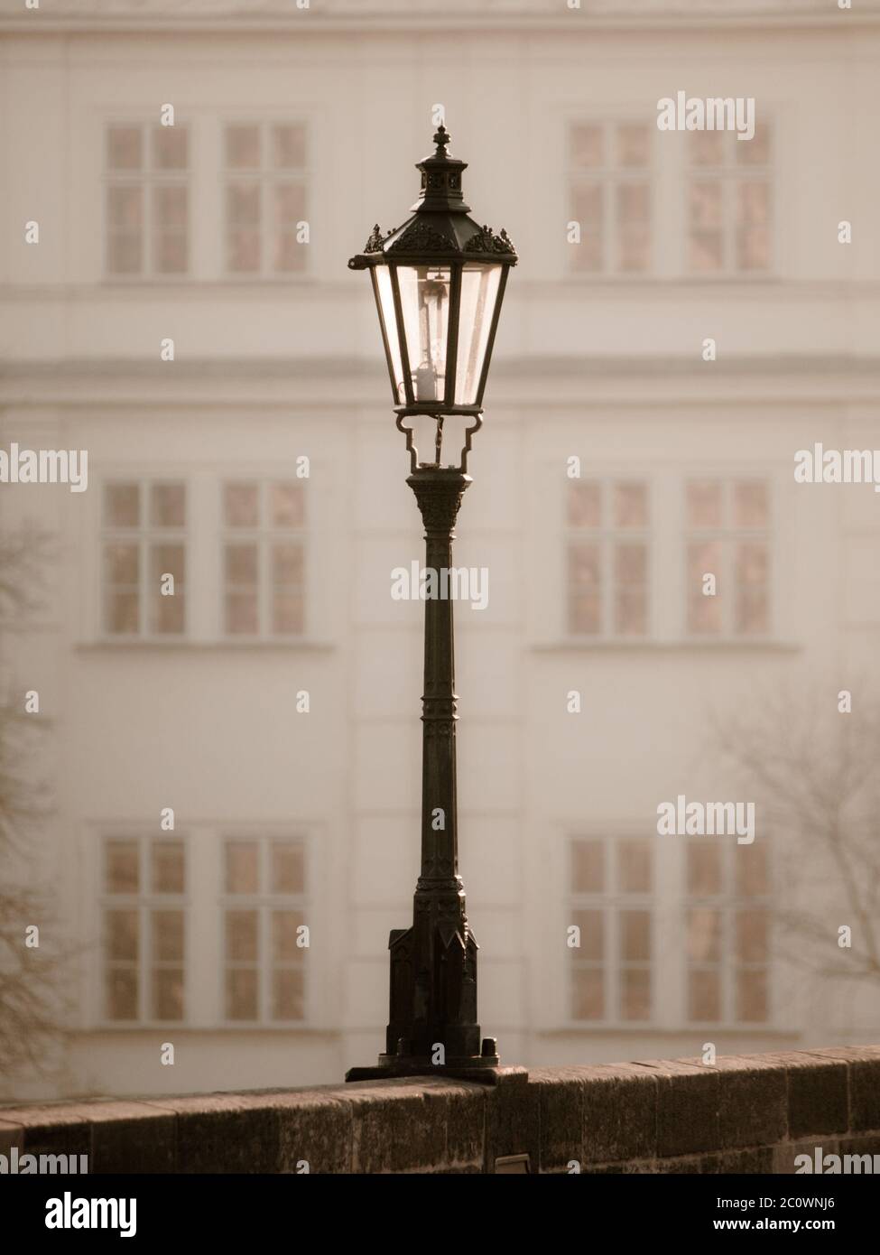 Street lamp on Charles Bridge in foggy morning, Prague, Czech Republic. Sepia image. Stock Photo