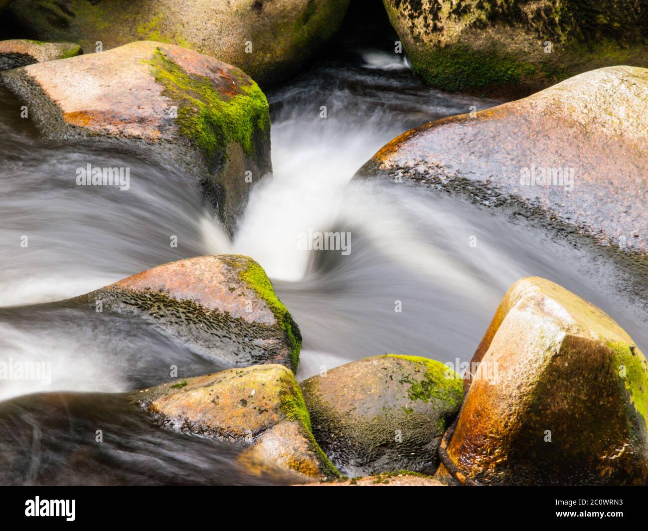 Blurred river stream detail of wild rocky mountain river. Silky effect. Motion rendition effect. Slow shutter speed effect. Long exposure effect. Stock Photo