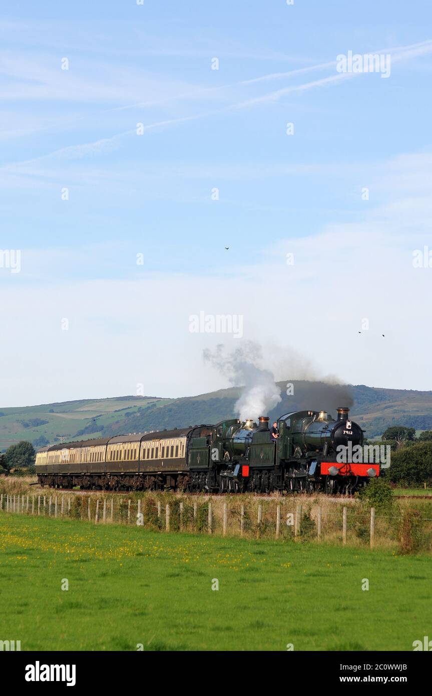 'Erlestoke Manor' and 'Foxcote Manor' approaching Blue Anchor Station with a Minehead - Bishops Lydeard train. Stock Photo