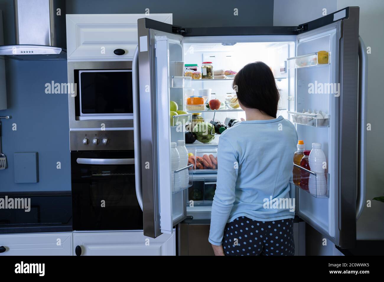 Hungry Woman At Night With Open Fridge Stock Photo - Alamy, image size:1300x956