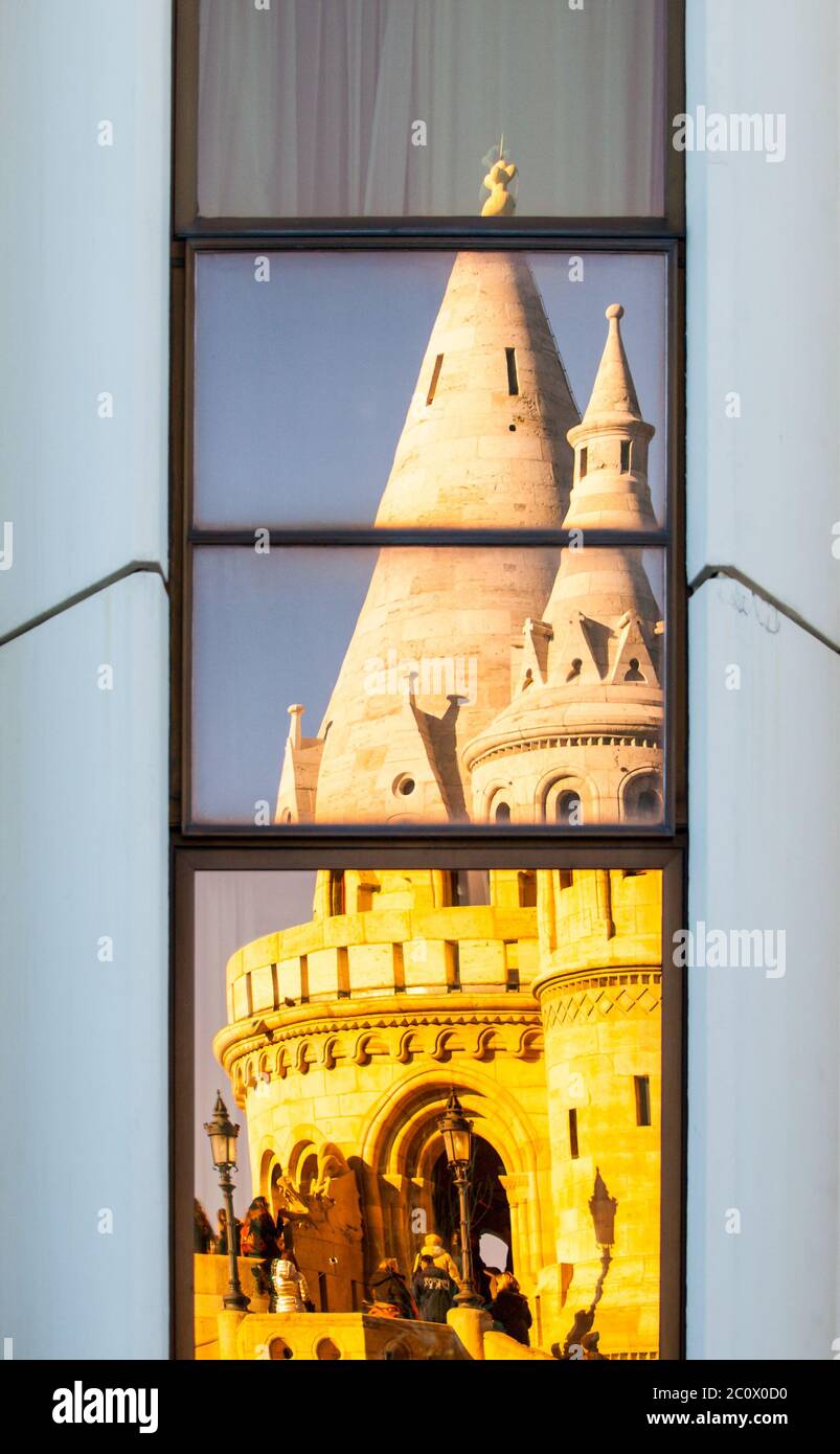 Detailed view of warped reflection of Fisherman's Bastion, aka Halaszbastya, fairy tale towers in windows of modern hotel. Architectural constrast of historical landmark and hated modern architecture of communistic Hungary. Budapest, capital city of Hungary, Europe. UNESCO World Heritage Site Stock Photo