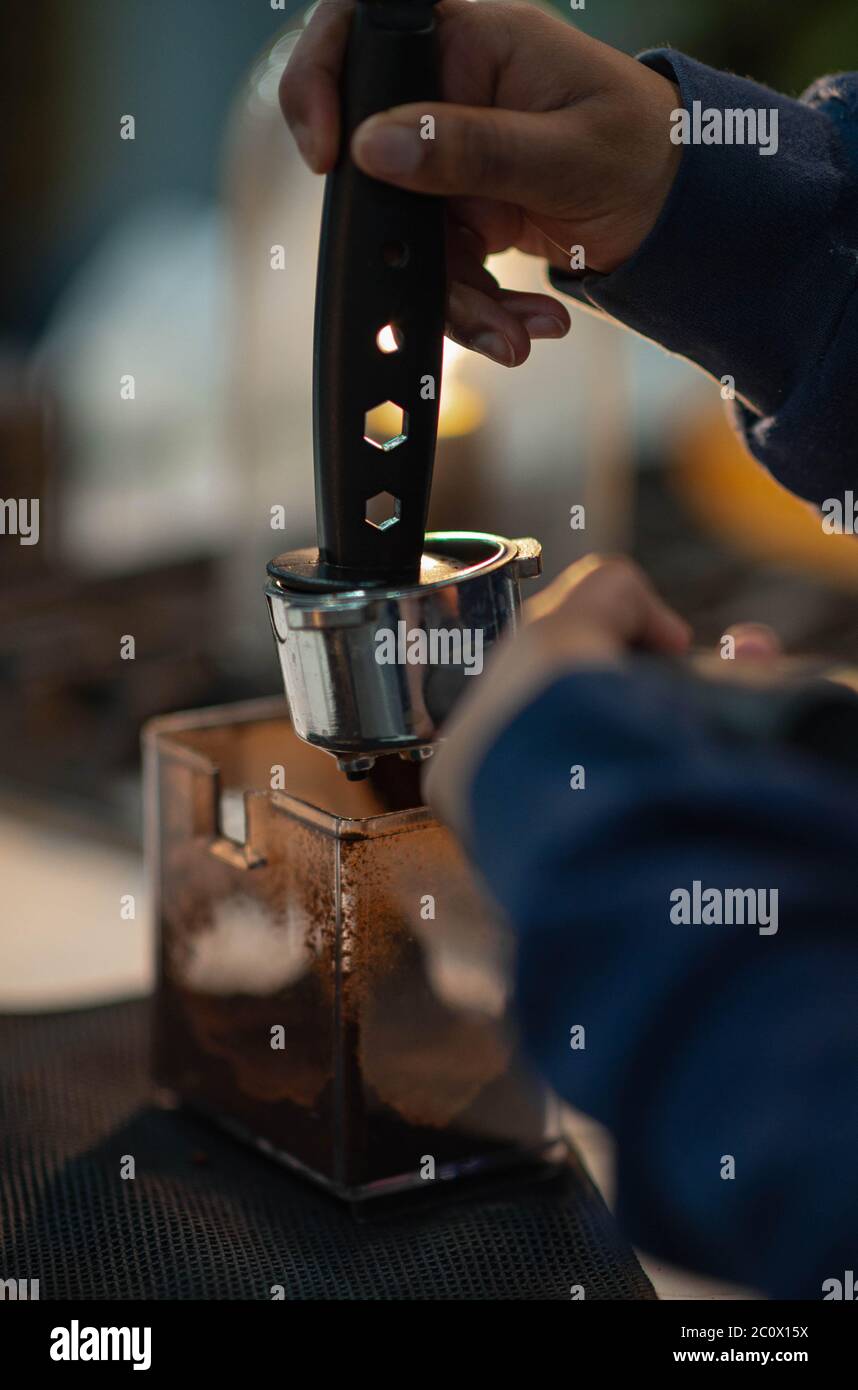 Barista presses ground coffee using tamper. Making Espresso Stock Photo
