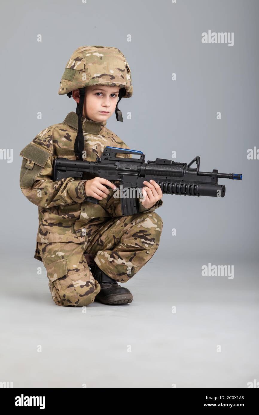 Young boy dressed like a soldier with rifle Stock Photo