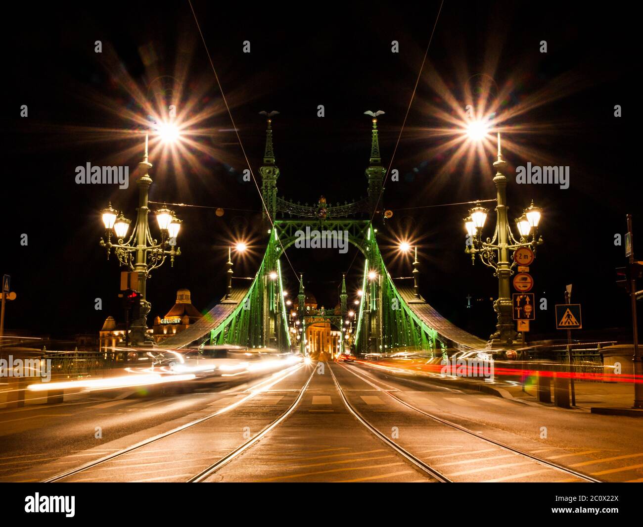 Front view of illuminated Liberty bridge in Budapest, Hungary. Night shot long exposure with car lights. Stock Photo