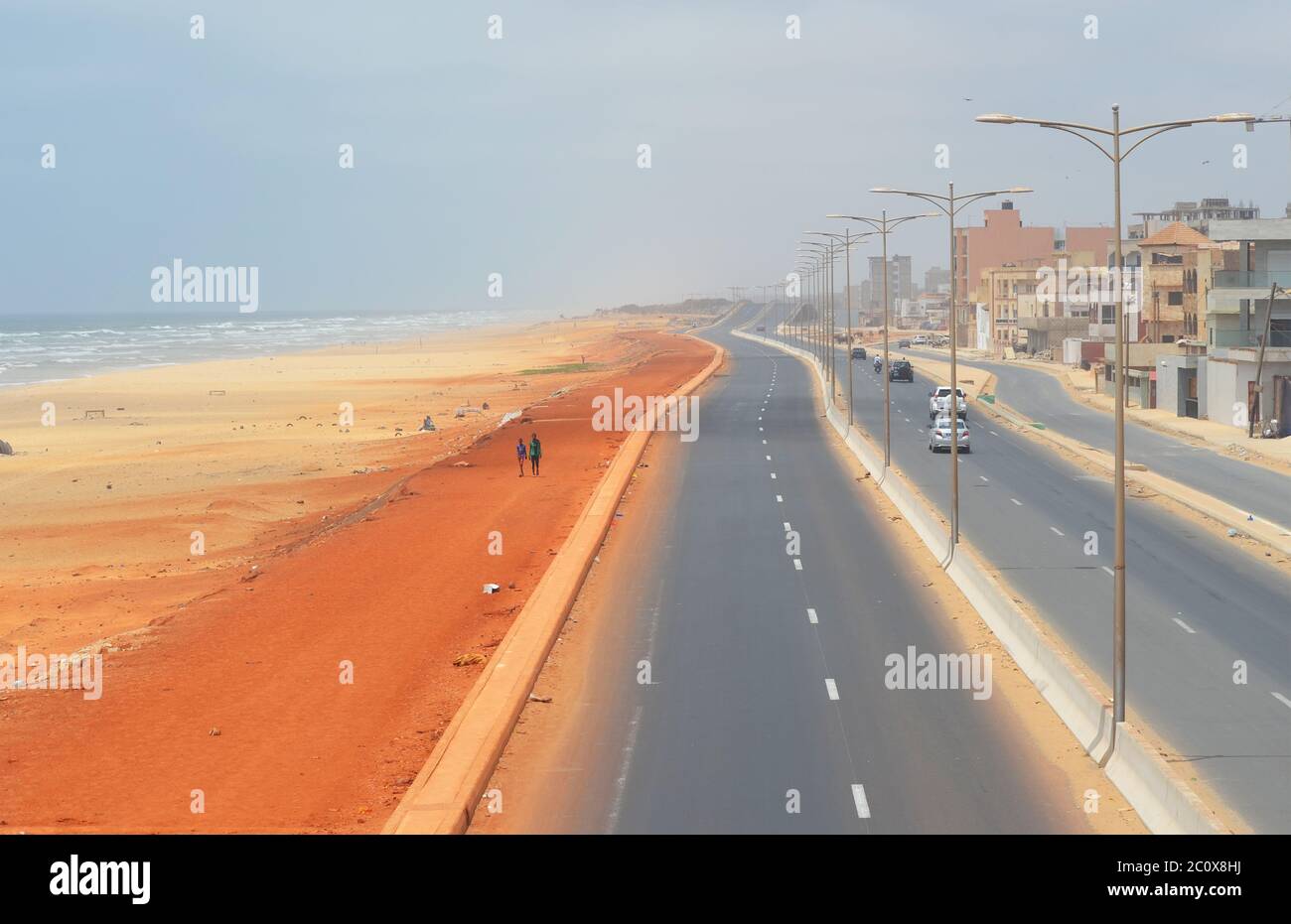 Almost empty coastal road and equally empty beach in the Guediawaye neighbourhood, Dakar, Senegal Stock Photo