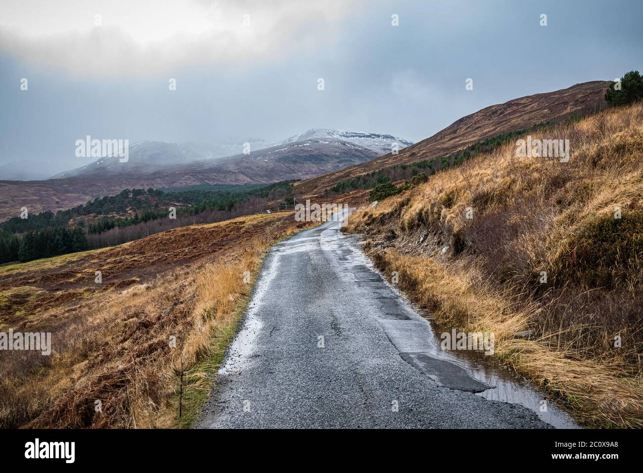 Single track road in Glen Lyon, Scottish Highlands. Winter landscape of Glen Lyon, Scotland on an overcast day. Stock Photo